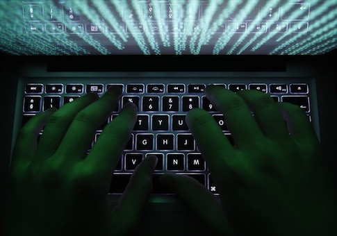 A man types on a computer keyboard in Warsaw