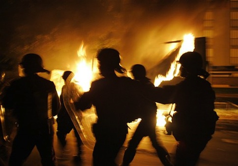 French riot police officers run past a burning truck in Paris suburb, Aulnay-sous-Bois