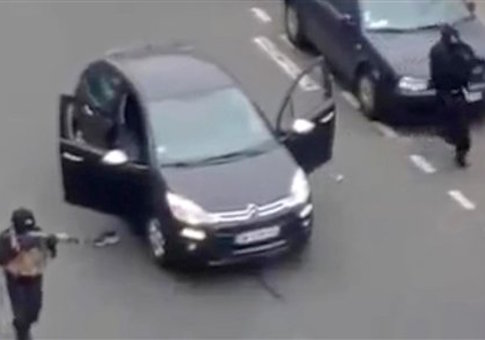 Masked gunman fire their weapons outside the French satirical newspaper Charlie Hebdo's office, in Paris, Wednesday, Jan. 7
