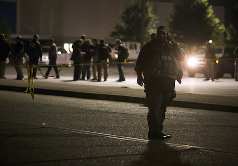 A member of the police stands outside a movie theatre where a man opened fire inside a crowded movie theater on Thursday night in Lafayette
