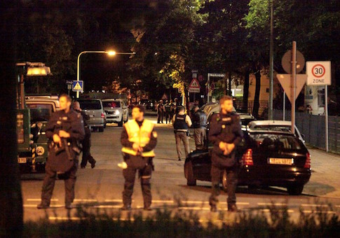 Police stand in a small street following a shooting rampage at the Olympia shopping mall in Munich