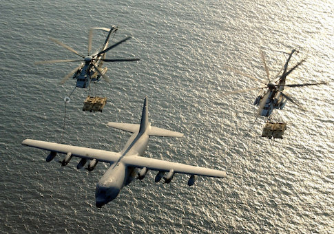 Two U.S. Marine Corps CH-53E Super Stallion helicopters receive fuel from a KC-130 Hercules over the Gulf of Aden
