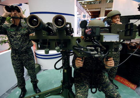 Three Taiwanese soldiers demonstrate a US-made dual mounted stinger missiles during the aerospace and defense technology exhibition at the World Trade Center in Taipei