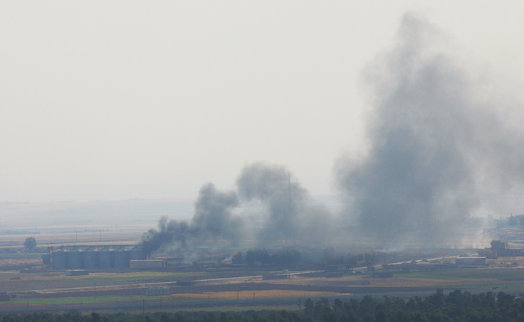 Smoke rises from a building near the Syrian town of Ras al-Ain as seen from the Turkish border town of Ceylanpinar