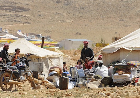 Refugees who fled the violence from the Syrian town of Flita, near Yabroud, stand outside their tents at the border town of Arsal