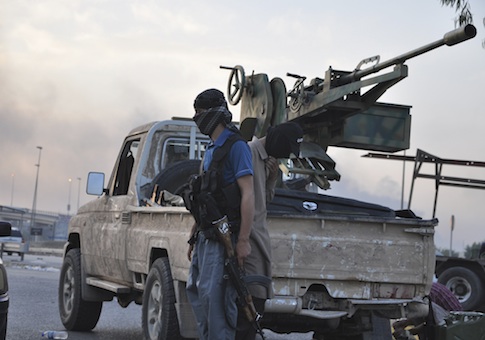 Fighters of the Islamic State of Iraq and the Levant (ISIL) stand guard at a checkpoint in the northern Iraq city of Mosul