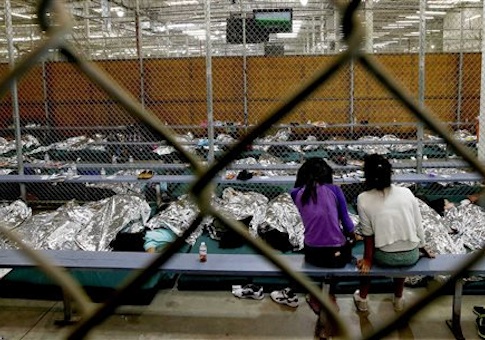 two young girls watch a World Cup soccer match on a television from their holding area where hundreds of mostly Central American immigrant children are being processed and held