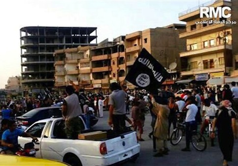 This undated file photo posted by the Raqqa Media Center, a Syrian opposition group, on Monday, June 30, 2014, which has been verified and is consistent with other AP reporting, shows fighters from extremist Islamic State group during a parade in Raqqa, Syria