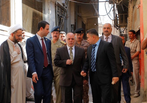Iraqi Prime Minister Haider al-Abadi (C) walks after a meeting with the top Shiite cleric, Grand Ayatollah Ali al-Sistani, in the Shiite holy city of Najaf, south of Baghdad, October 20, 2014