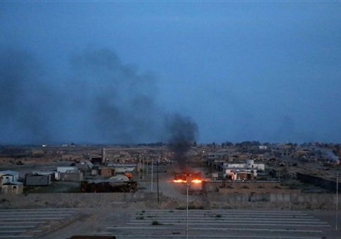 Smoke rises after clashes between Iraqi security forces and allied Shiite militiamen and Islamic State group extremists in the Qadisiyya neighborhood in Tikrit