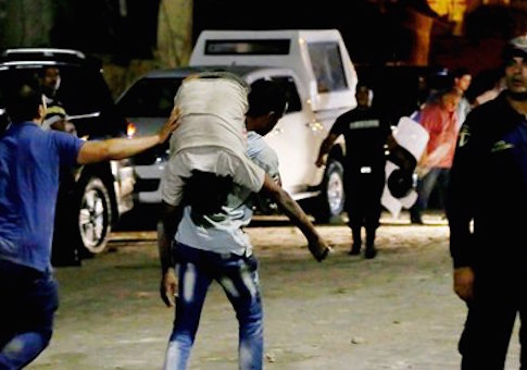 A wounded man is carried from the site of the car bomb in Cairo