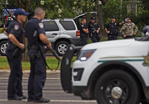 Law enforcement officers man a road block on Airline Highway and Goodwood Blvd. after police were shot earlier in the day in Baton Rouge, La.