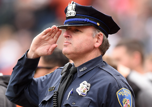 A Baltimore city police officer during the National Anthem at a baseball game / Getty Images