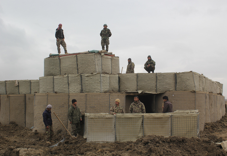 Afghan National Army (ANA) soldiers stand at a checkpost, where last night clashes took place between Taliban and Afghan forces in Kunduz, Afghanistan