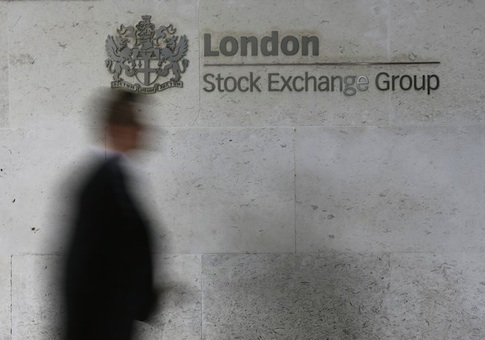 A man walks past the London Stock Exchange in the City of London