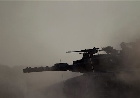 An Israeli tank takes a position along the Israel-Gaza Border