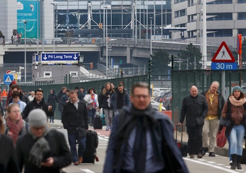 People leave the scene of explosions at Zaventem airport near Brussels, Belgium