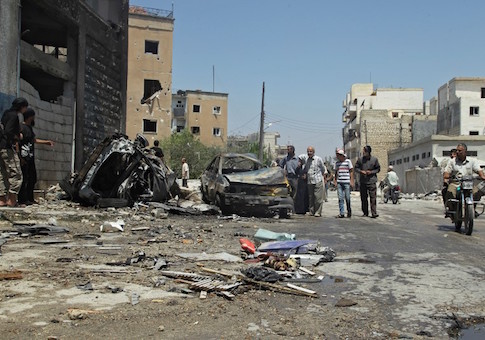 Civilians inspect a site hit by an airstrike in the rebel-controlled city of Idlib