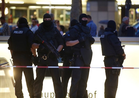 Special force police officers stand guard at entrance of main train station following shooting rampage at shopping mall in Munich