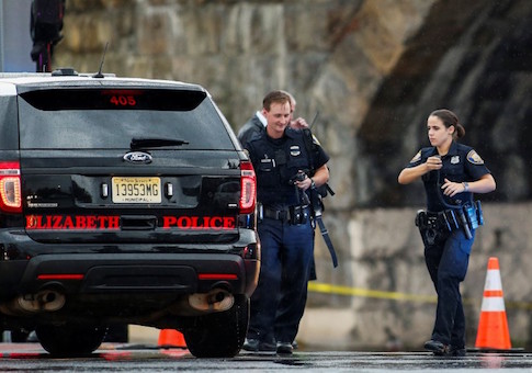 Police officers walk near the area where an explosive device left at a train station was detonated by the authorities in Elizabeth, New Jersey