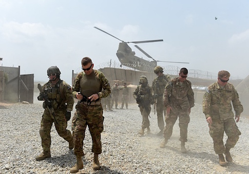 US army soldiers walk as a NATO helicopter flies overhead at coalition force Forward Operating Base (FOB) Connelly in the Khogyani district in the eastern province of Nangarhar