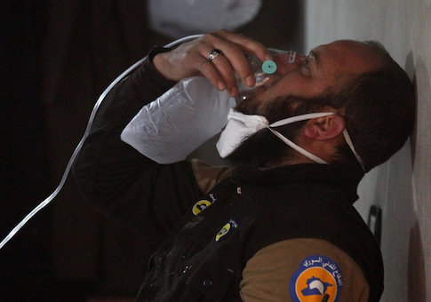 A civil defense member breathes through an oxygen mask, after what rescue workers described as a suspected gas attack in the town of Khan Sheikhoun in rebel-held Idlib