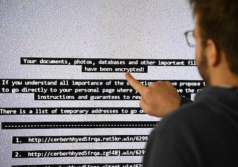 An IT researchers shows on a giant screen a computer infected by a ransomware