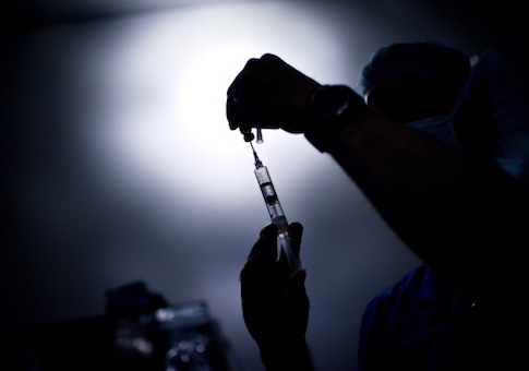 A doctor draws medicine into a syringe d