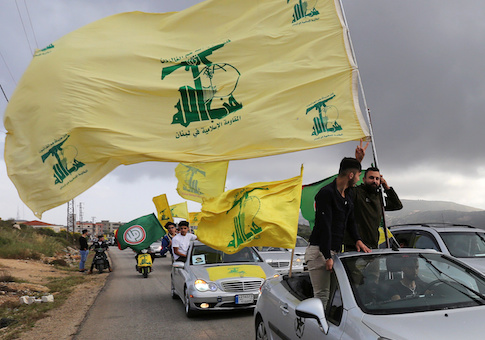 A supporter of Lebanon's Hezbollah gestures as he holds a Hezbollah flag in Marjayoun