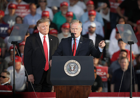 President Donald Trump looks on as Fred Keller speaks
