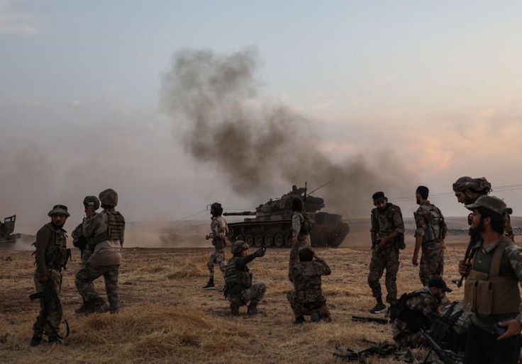 Turkish soldiers and Turkey-backed Syrian fighters gather on the northern outskirts of the Syrian city of Manbij near the Turkish border