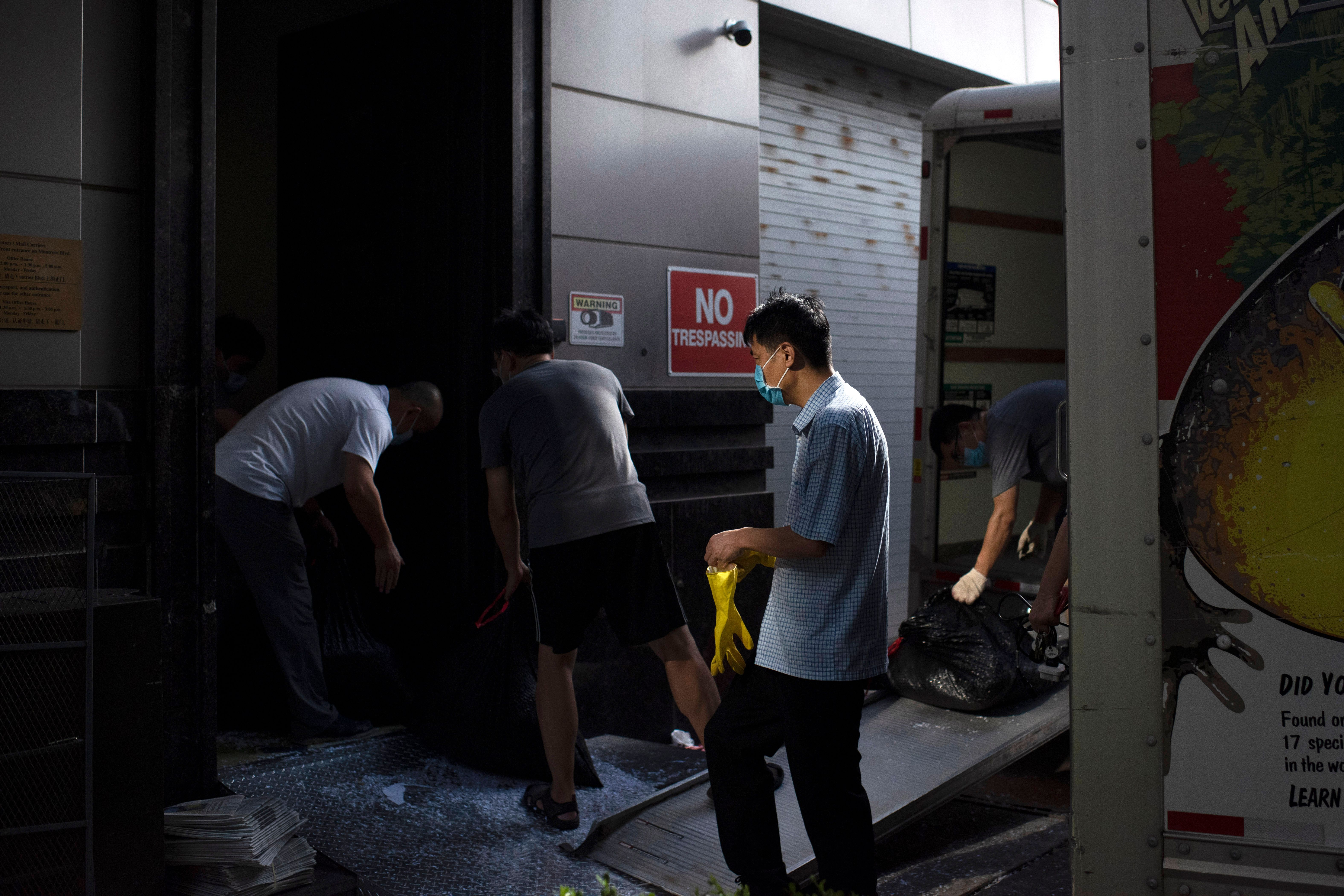 People move trash bags from the Chinese consulate in Houston on July 24