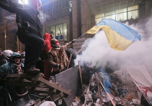 Pro-European Union activists guard the barricade during clashes with riot polic