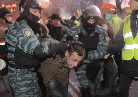 Ukrainian riot policemen pull a Pro-European Union activist out from a tent camp