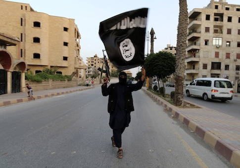 A member loyal to the Islamic State in Iraq and the Levant (ISIL) waves an ISIL flag in Raqqa June 29, 2014