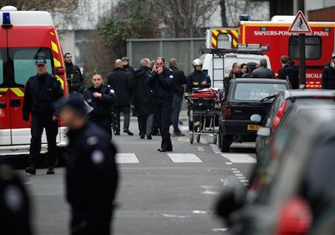 Police officers and firemen gather outside the French satirical newspaper Charlie Hebdo's office, in Paris, Wednesday, Jan. 7