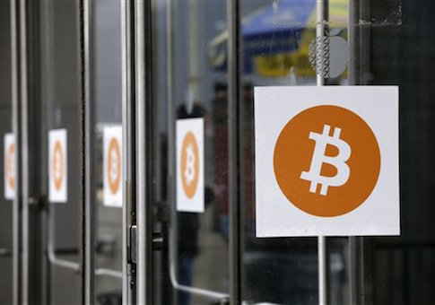 Bitcoin logos are displayed at the Inside Bitcoins conference and trade show, Monday, April 7, 2014 in New York