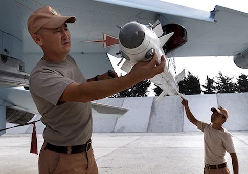 Russian ground staff members load a Sukhoi Su-30 fighter jet with weapons at the Hmeymim air base near Latakia, Syria / Reuters