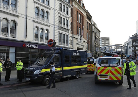 Police officers stand on duty outside an entrance to Borough Market on Borough High Street in London on June 7, 2017, after a police cordon was reduced following the June 3 terror attack