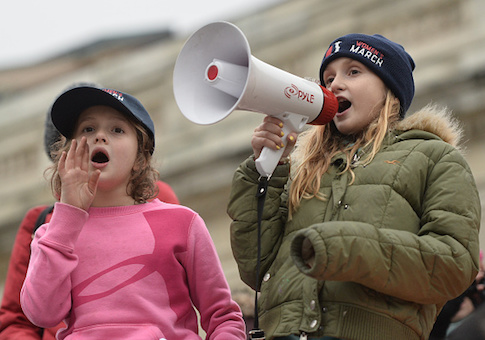 Young protesters shout on the National Mall in Washington, DC, for the Women's March