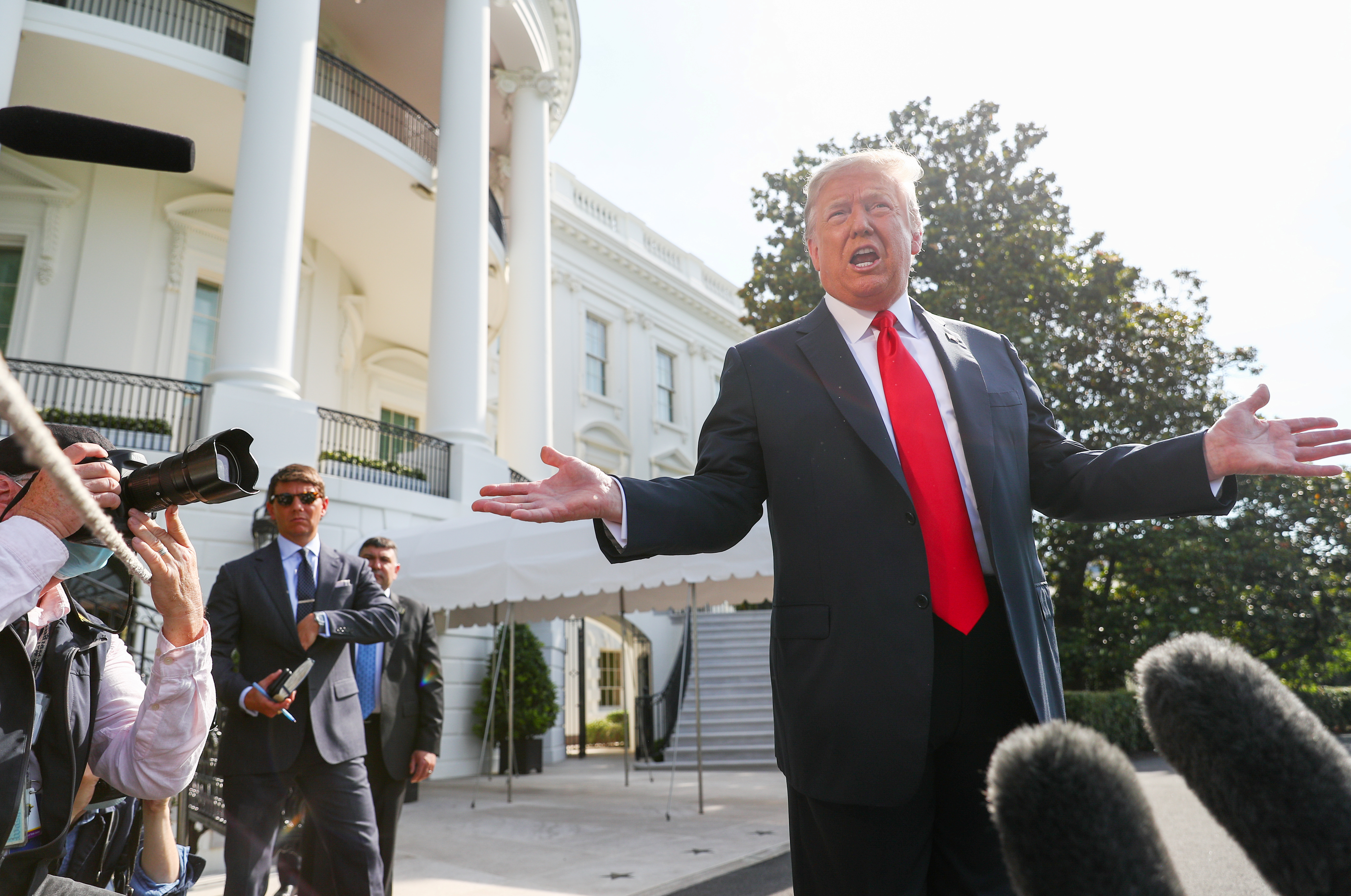 President Trump talks to reporters as he departs for a trip to Arizona at the White House in Washington